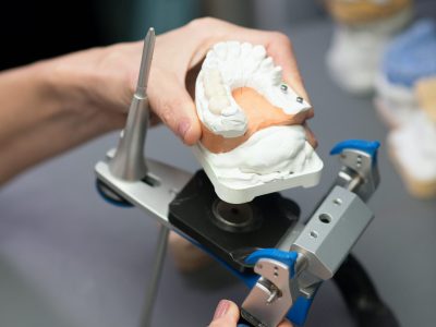 Dental prosthesis. Prosthetist working with equipment at the dental clinic